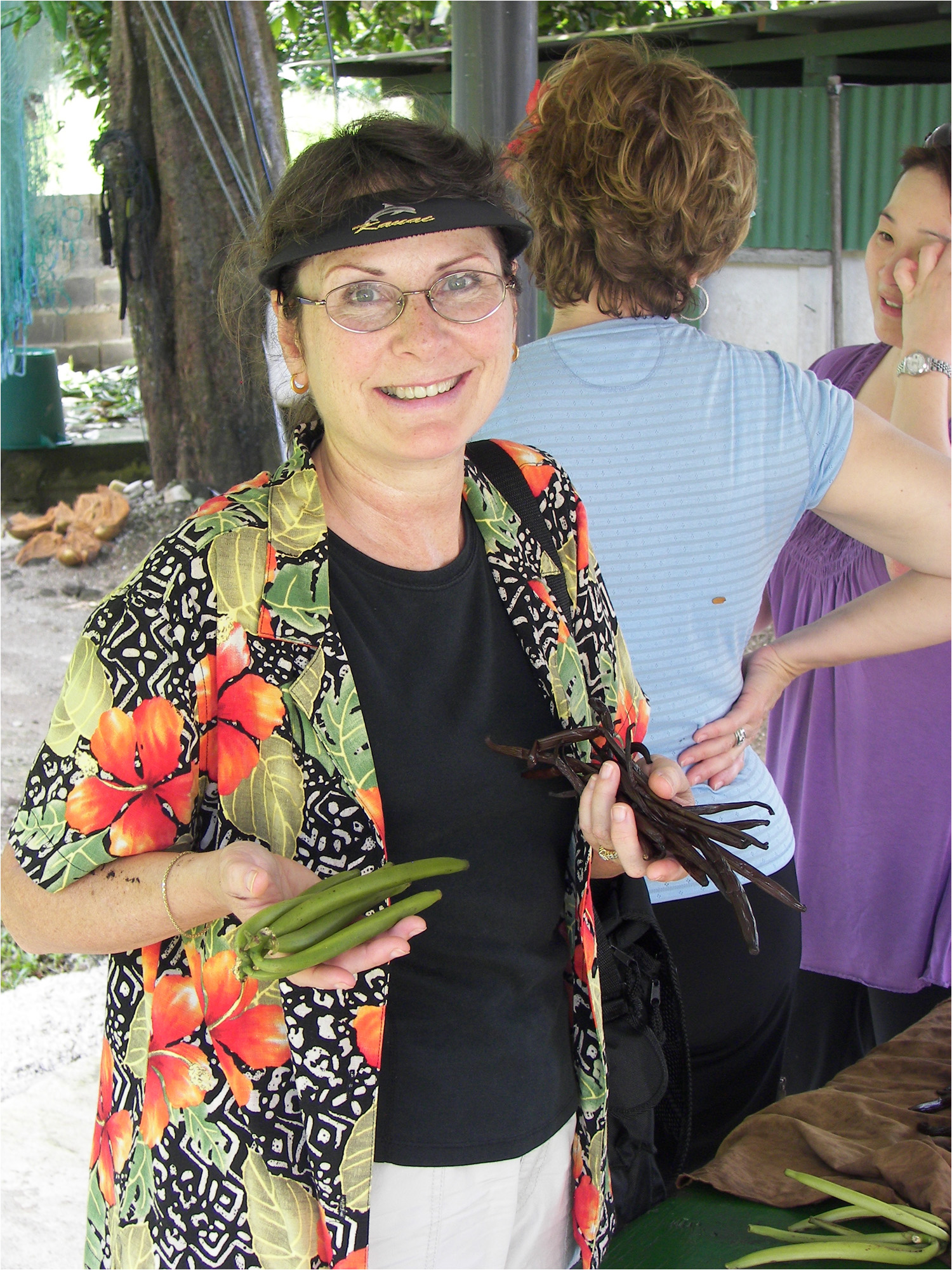 Katherine holding vanilla beans before and after ripening process.